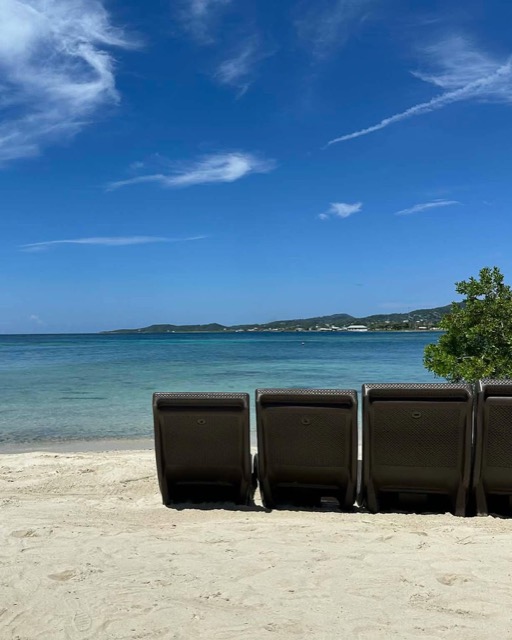 Beach loungers facing turquoise water