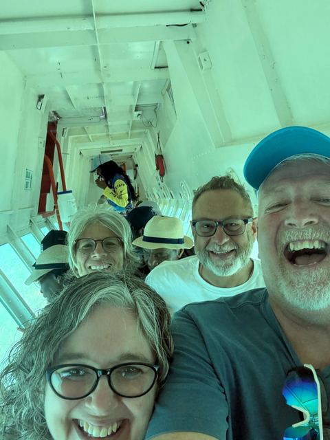 Guests laughing inside the glass-bottom boat above the viewing panels
