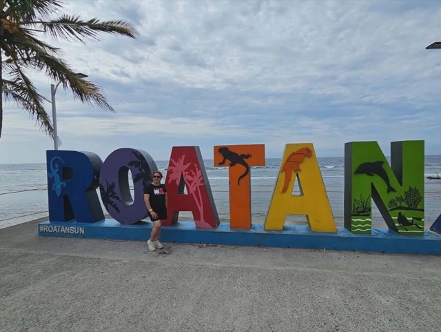 The ROATÁN sign with the beach behind