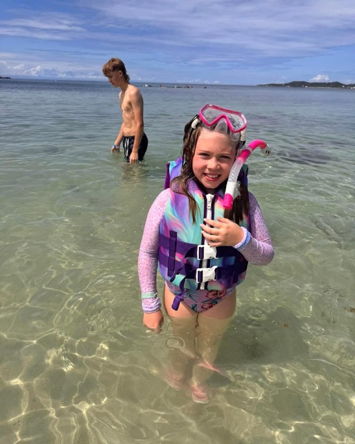 Young snorkeler wading in crystal-clear shallows