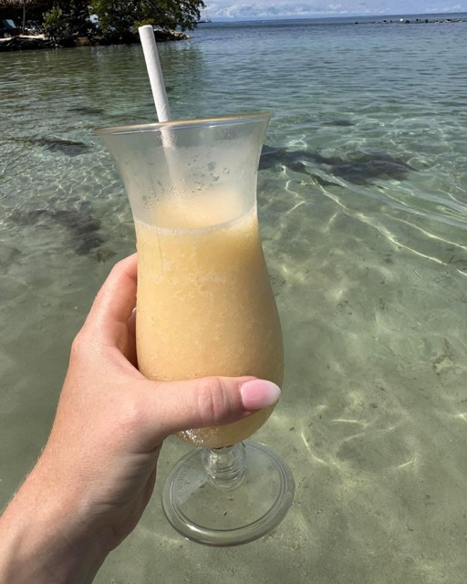 A fresh piña colada held over the lagoon
